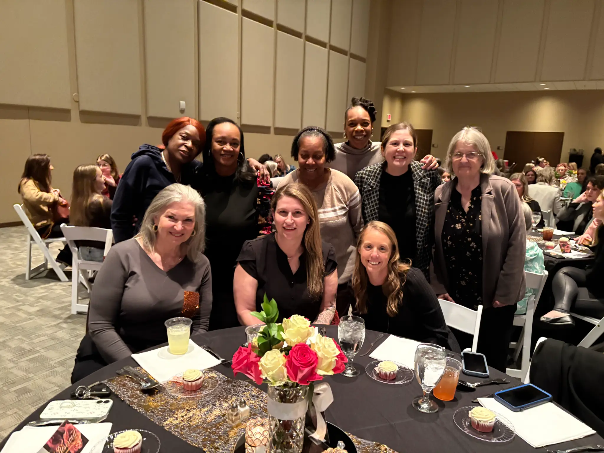 A group of women smiling together at a community event