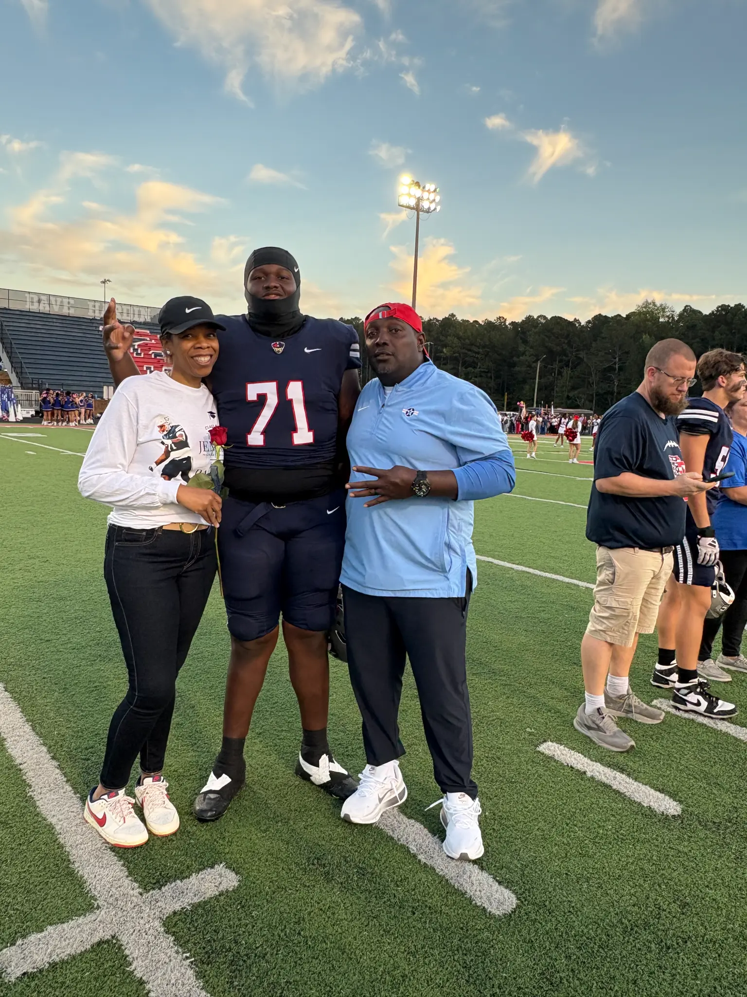 Atiyah with her husband and son on a football field